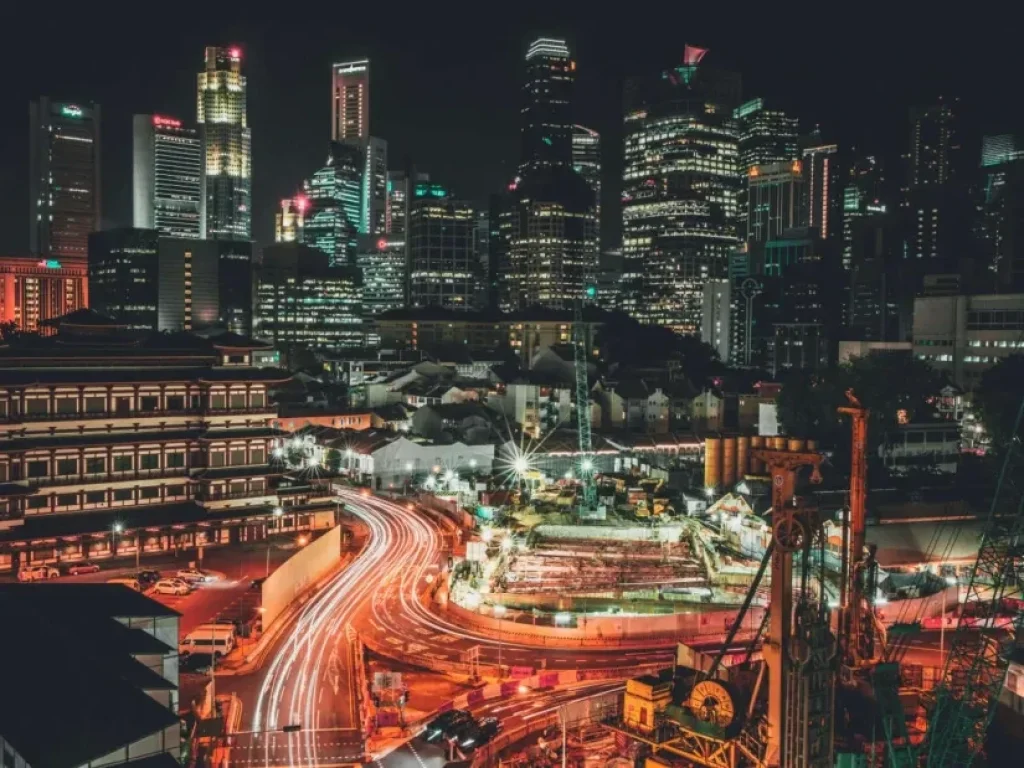 Singapore city at night with skyscrapers, houses, and lights.
